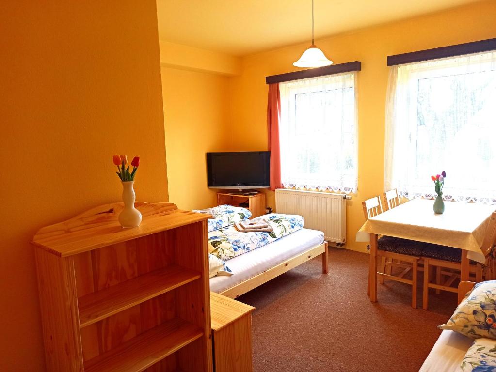 a small room with a bed and a table and window at P&P Jičín Apartments - soukromé 2-3 lůžkové pokoje s vlastní kuchyní a koupelnou in Jičín