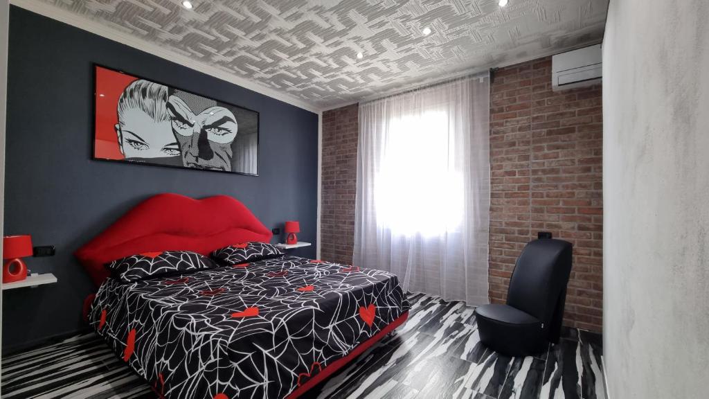 Un dormitorio con una cama negra y roja y una ventana en Diaboliko Apartment, en Capoliveri