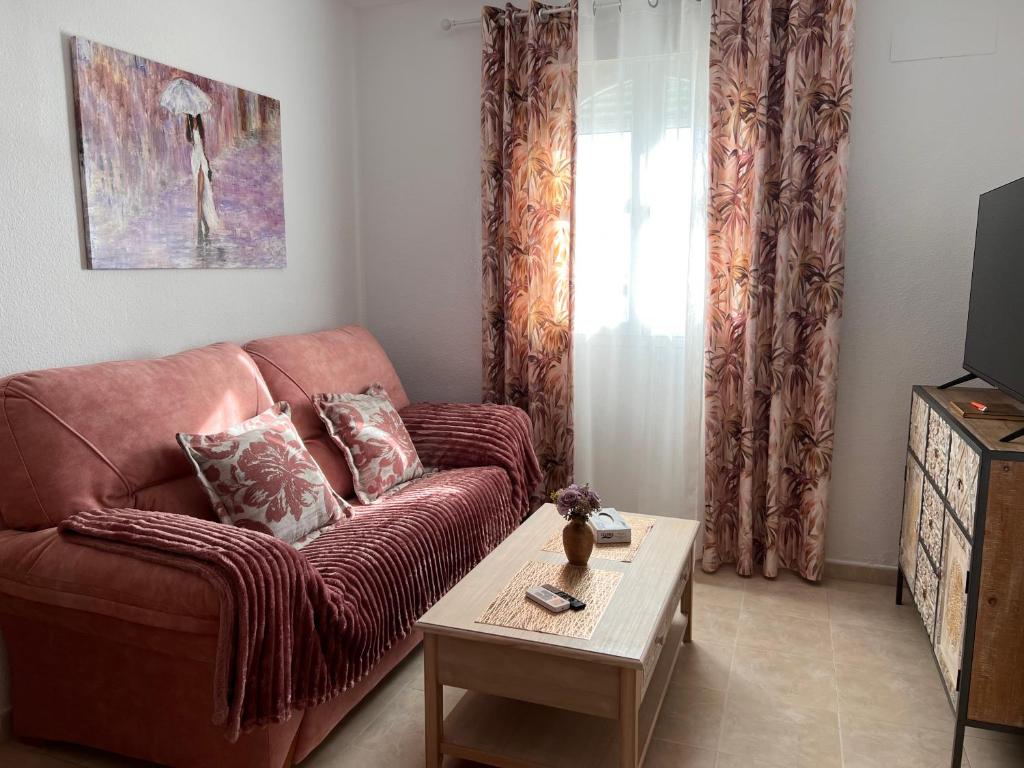 a living room with a brown couch and a table at Estudios Costavigía Mazagón by Ramona in Mazagón