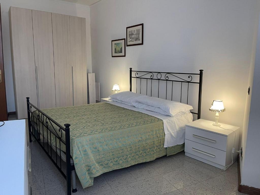 1 dormitorio con 1 cama grande y mesita de noche con 2 lámparas en Da Laura, en Brunate