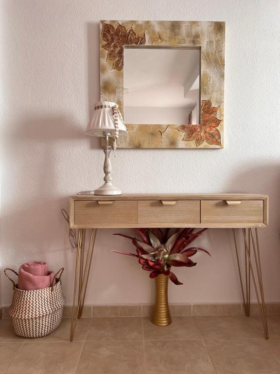 a dressing table with a mirror and a lamp at Estudios Costavigía Mazagón by Ramona in Mazagón