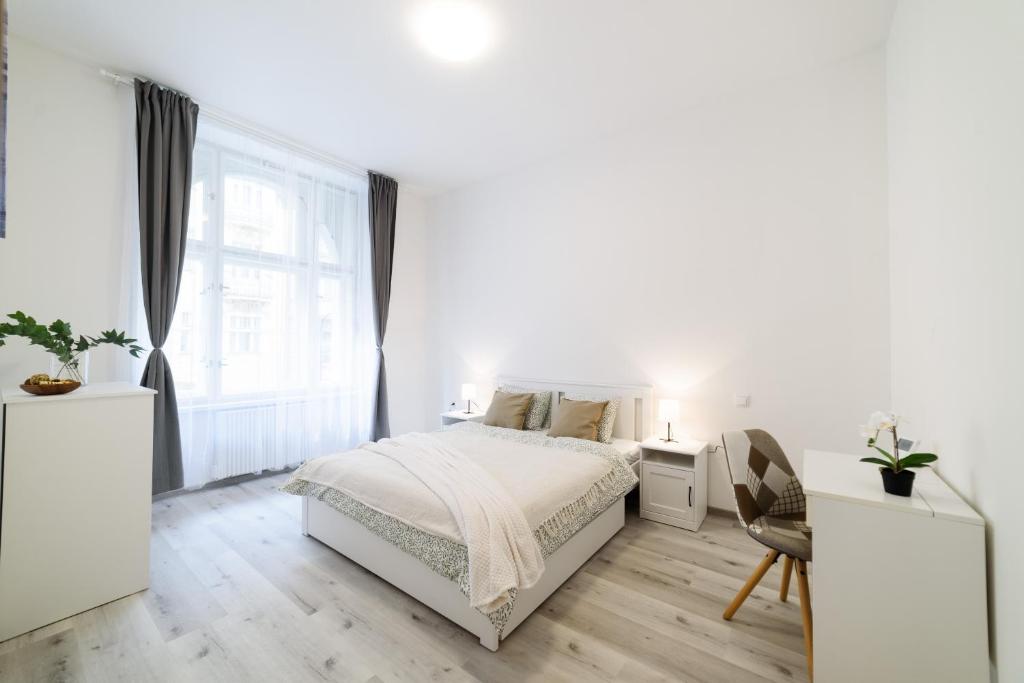 ein weißes Schlafzimmer mit einem Bett und einem Fenster in der Unterkunft New apartments near Dancing house in Prag