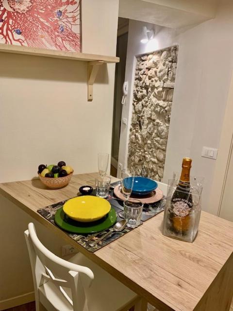 a table with a yellow plate and a bottle of wine at La Rovettina Pet friendly house in Salò