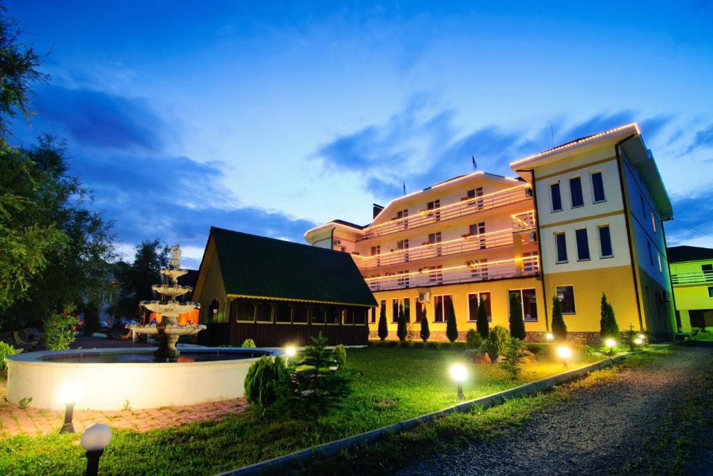 a building with a fountain in the middle of a yard at Hotel Continent in Polyana