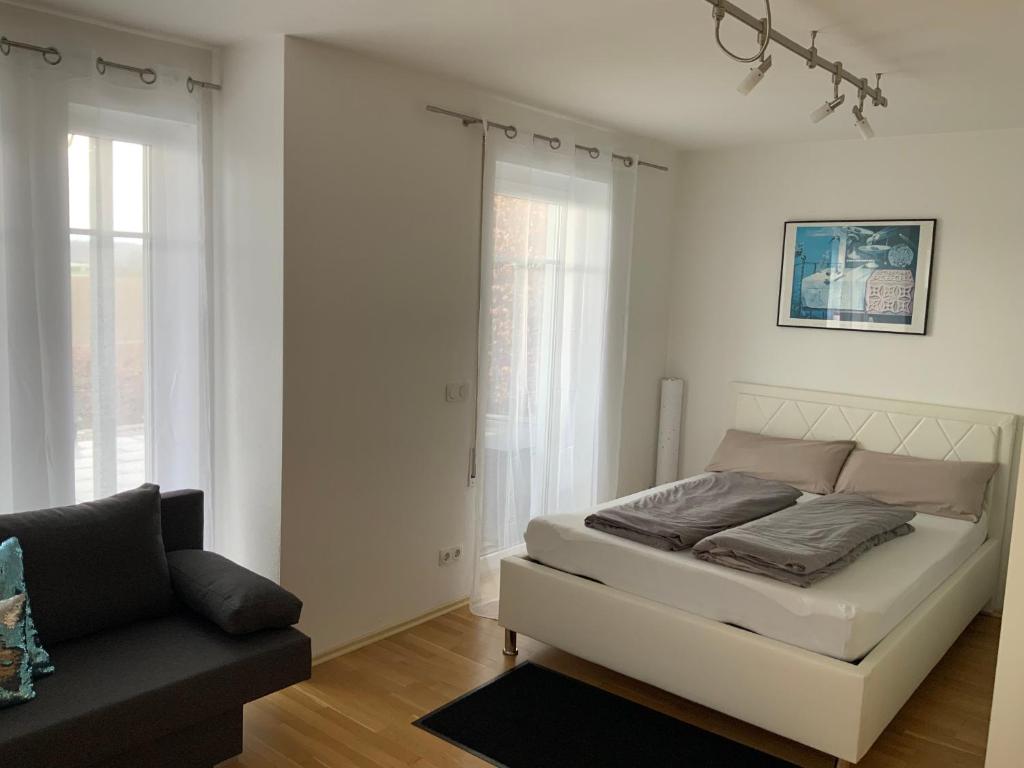 Habitación blanca con cama y sofá en Apartment „Am Südhang“, en Odelzhausen