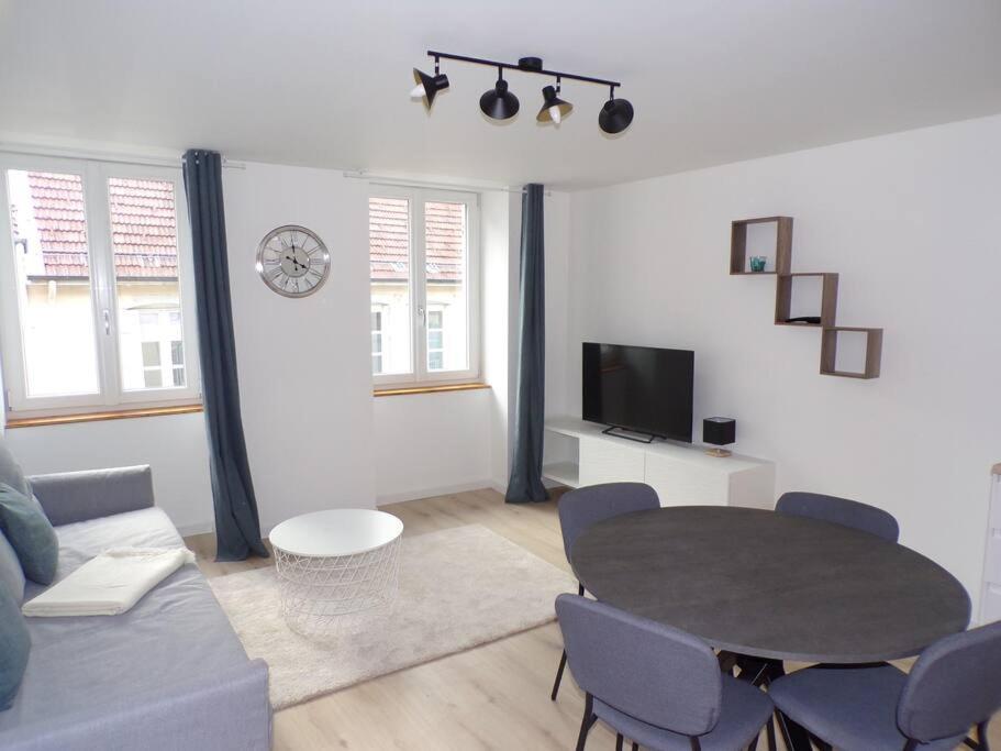 un salon avec une table et un canapé dans l'établissement Appartement 2/4 pers, 44m2, hypercentre., à Lons-le-Saunier