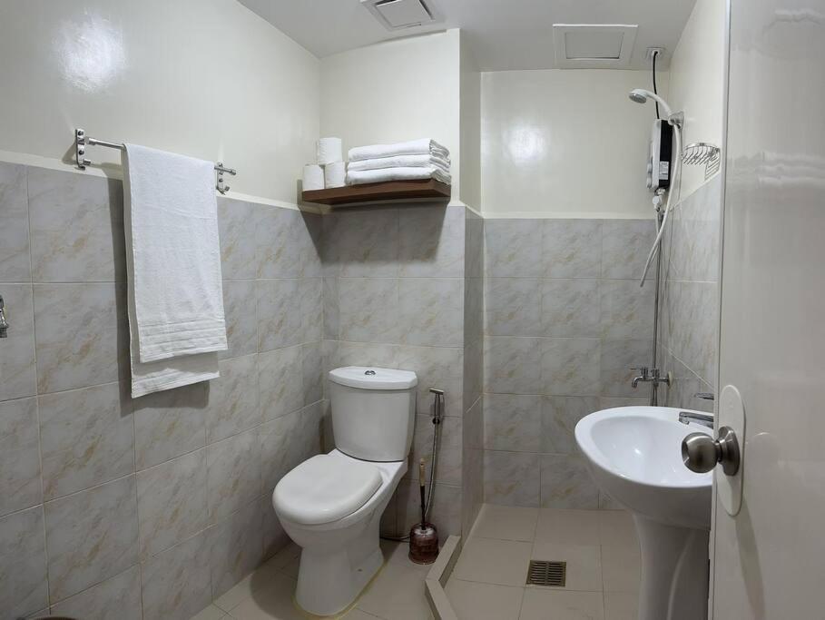 uma casa de banho branca com um WC e um lavatório em 2 BR Unit In Seawind Condo [New&FullyFurnished] em Davao