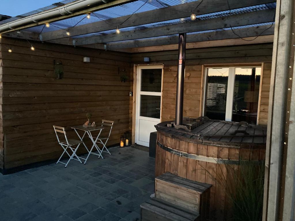 un patio al aire libre con parrilla y mesa en L'Eddy lodge en Neufchâteau