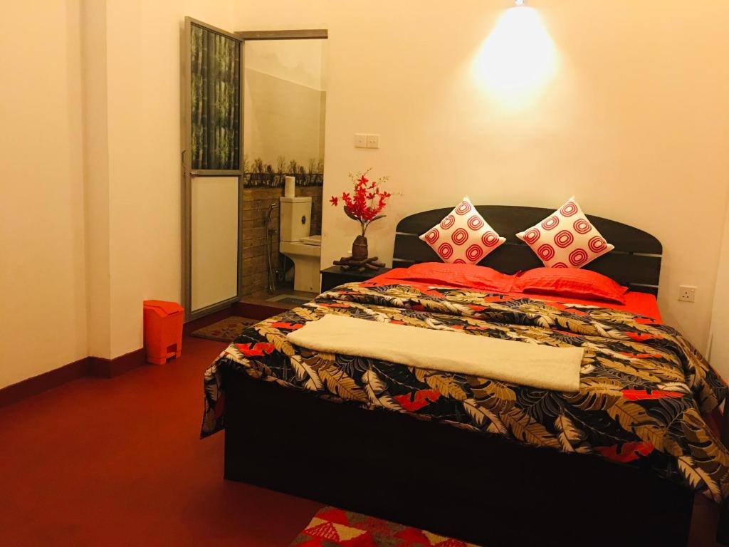 1 dormitorio con 1 cama grande con almohadas rojas en Little wood villa Doluwa, en Kandy