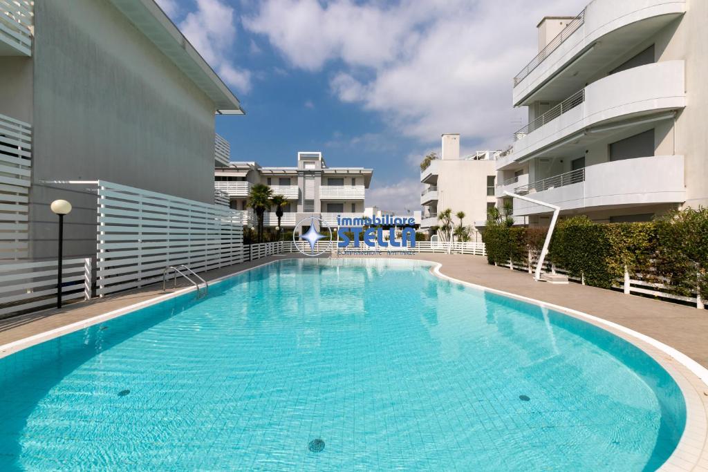 a large swimming pool next to a building at Residence Maricel in Lido di Jesolo
