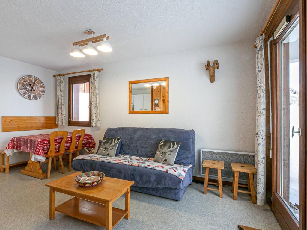 a living room with a blue couch and a table at Appartement La Clusaz, 2 pièces, 4 personnes - FR-1-437-78 in La Clusaz