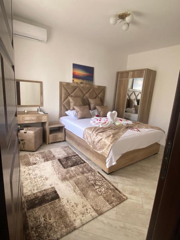 a bedroom with a large bed and a mirror at Apartments Gusar in Ulcinj