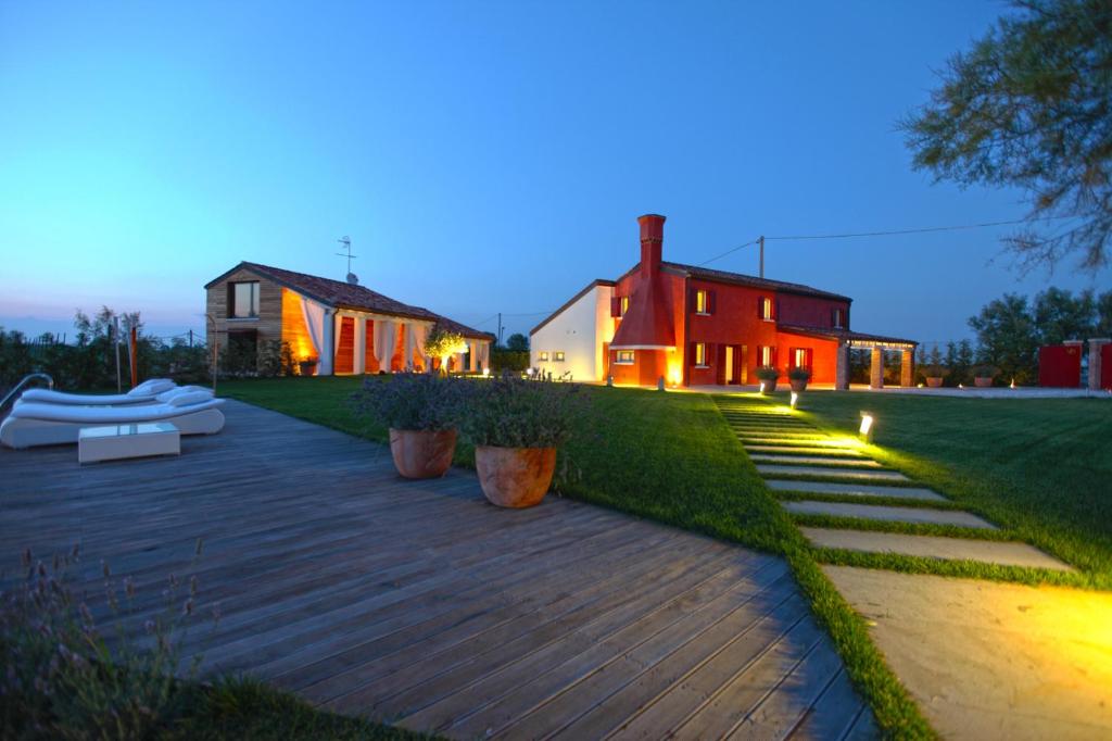 a backyard with a wooden walkway in front of a house at Villa Sacchetta in Cavallino-Treporti