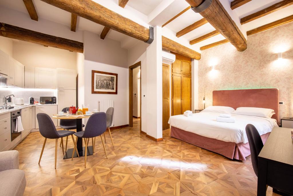 1 dormitorio con 1 cama, mesa y sillas en Falegnami Boutique Suites - BolognaRooms, en Bolonia