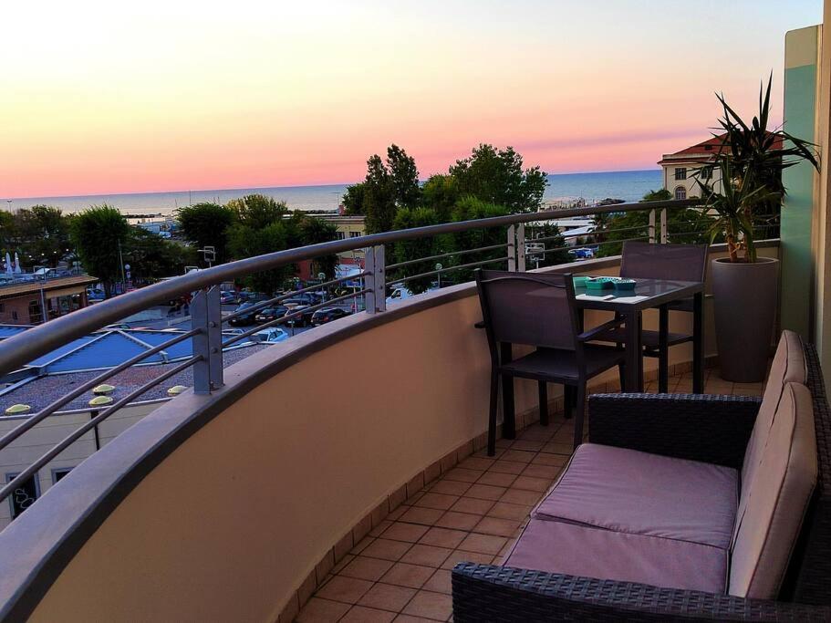 d'un balcon avec une table et des chaises donnant sur l'océan. dans l'établissement VistaMare Bluemar - The Art of the Sea - 105mq, à Cattolica