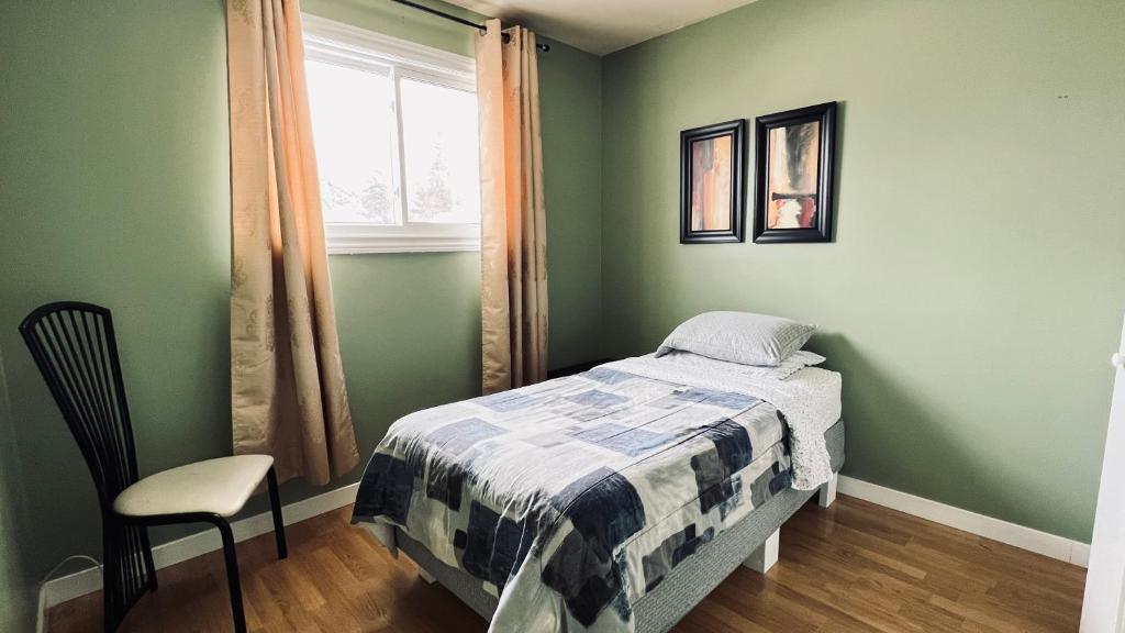 1 dormitorio con paredes verdes, 1 cama y 1 silla en Private Rooms Male Accommodation Close to NAIT Kingsway Mall Downtown en Edmonton