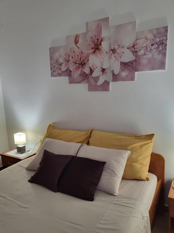 a bedroom with a bed with two paintings on the wall at Licul Apartment in Rovinj