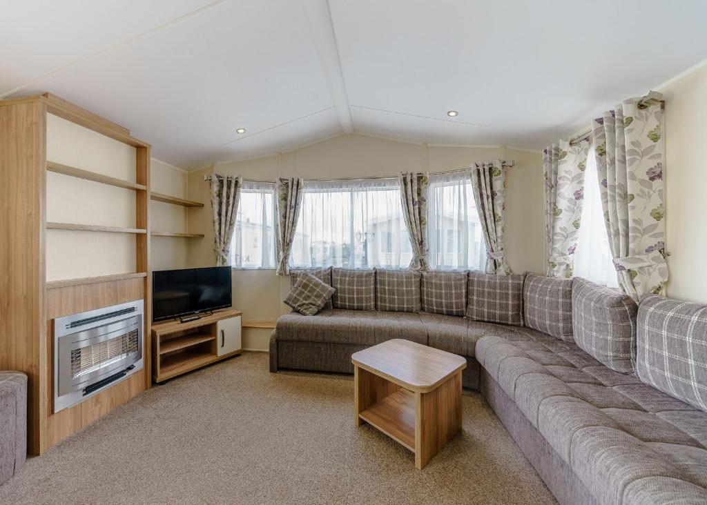 a living room with a couch and a television at Riverside Holiday Village 