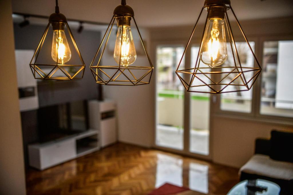 three lights hanging from the ceiling in a living room at goltepirot in Pirot