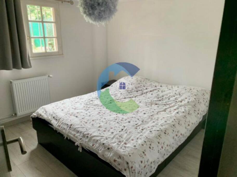 a bedroom with a bed with a comforter on it at appartement au rez de jardin in Morangis
