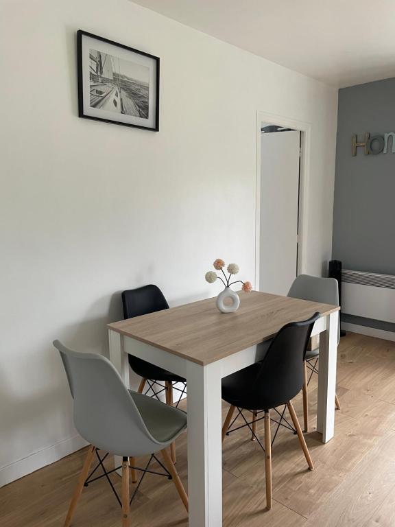Appartement vue sur la Rhune في ساري: طاولة طعام وكراسي في الغرفة