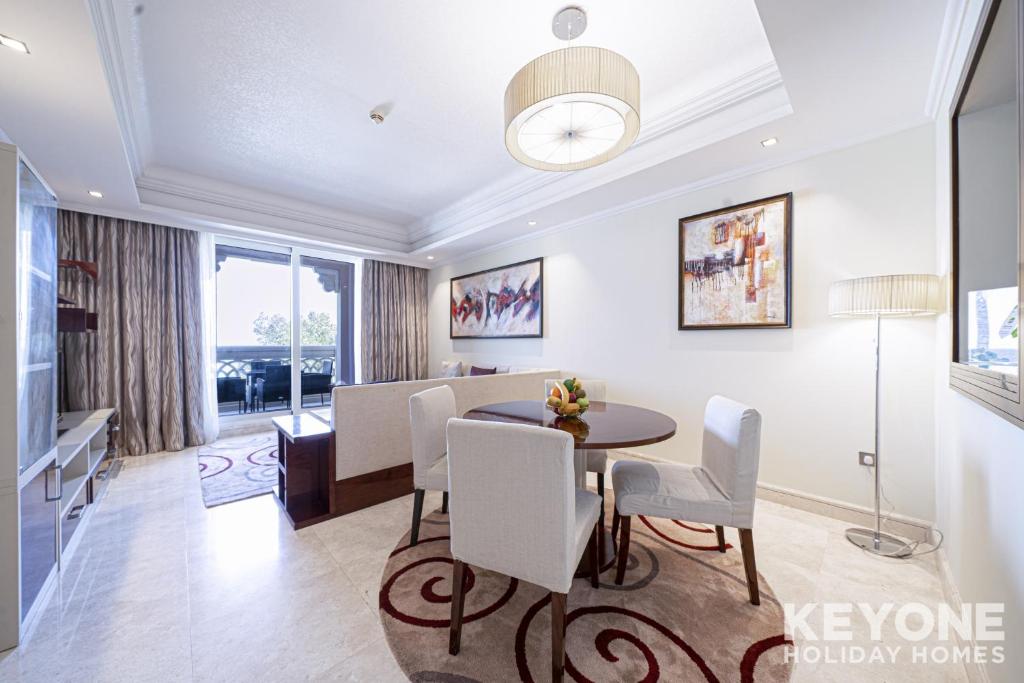 een eetkamer en een woonkamer met een tafel en stoelen bij Two Bedroom Sea View Apt with Private Beach Access in Dubai
