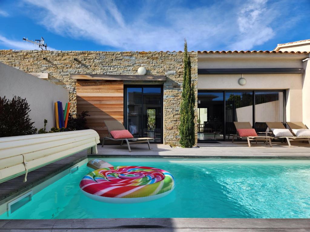 - une piscine avec des nouilles gonflables dans une maison dans l'établissement Villa HOME HOLIDAY à Cala Rossa, à Lecci