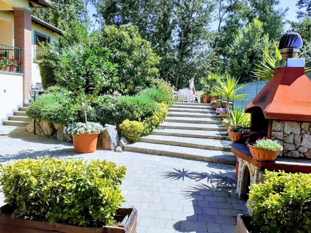 un giardino con piante e un sentiero in pietra di La Casa Più Sù a Manziana