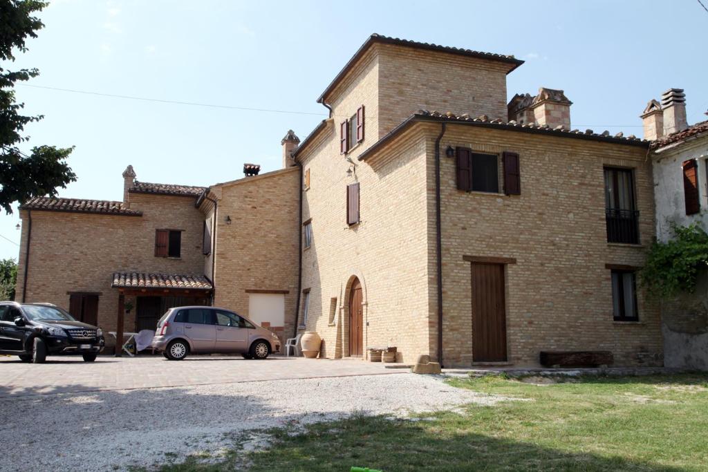 un edificio con coches estacionados frente a él en Agriturismo Sant'Antonio en Montegridolfo