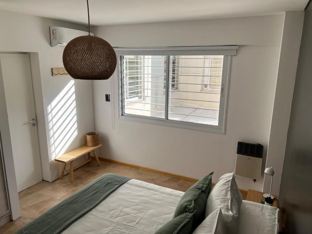 a bedroom with a bed and a large window at Departamento INDIGO in Mendoza