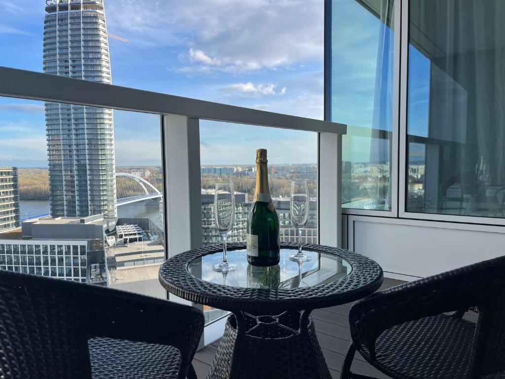 eine Flasche Champagner auf dem Tisch auf dem Balkon in der Unterkunft Panorama City apartment 2 rooms 19th floor, free parking in Bratislava