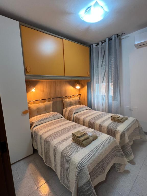 two beds in a hotel room with towels on them at Civico 13 in Scardovari