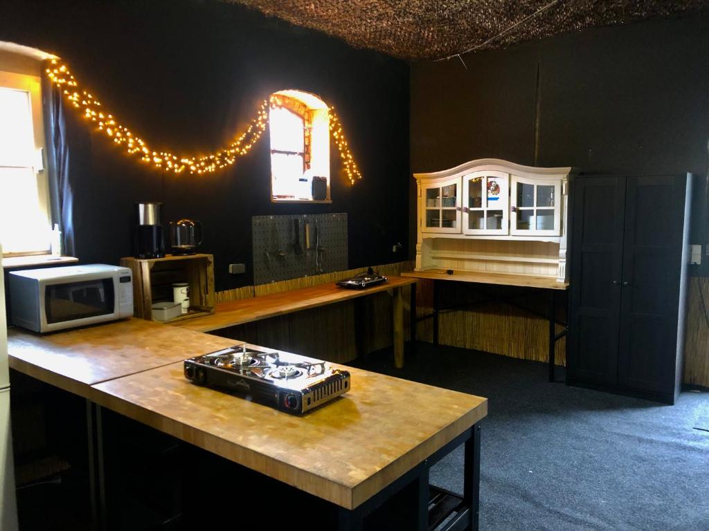 uma cozinha com um balcão com um micro-ondas e uma mesa em Kuckunniwi Tipidorf em Werder
