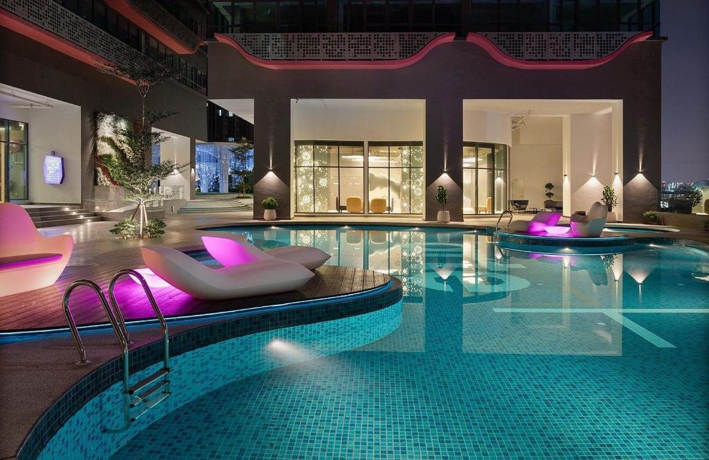 een zwembad met ligstoelen en een zwembad bij Kuala Lumpur Arte 3Bedrooms Master Residence in Kuala Lumpur
