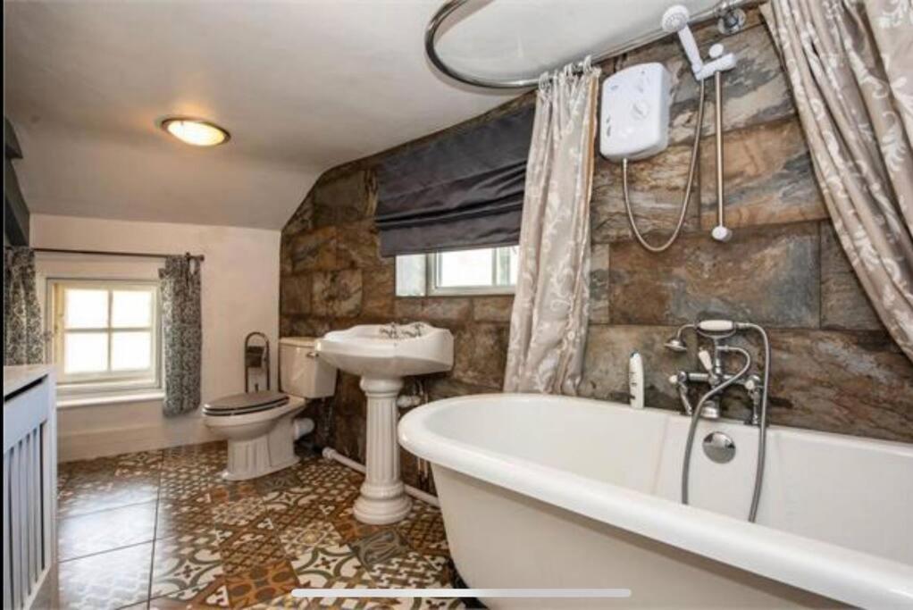a bathroom with a tub and a sink and a toilet at Quirky Cottage in the Heart of Appleby in Appleby