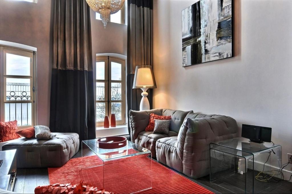 a living room with a leather couch and a table at Les Immeubles Charlevoix - Le 1180 in Quebec City
