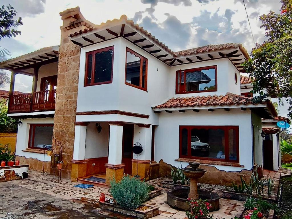Casa blanca con ventanas rojas en un patio en CASONA DE LOS VIRREYES, en Villa de Leyva