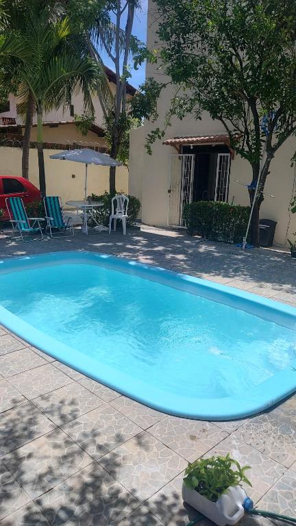 a large blue swimming pool in front of a house at Get Up Hostel in Natal