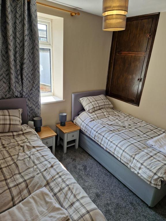 a bedroom with two beds and a window at Lovely Cosy Two Bed Home,Peak District Gateway in Buxton