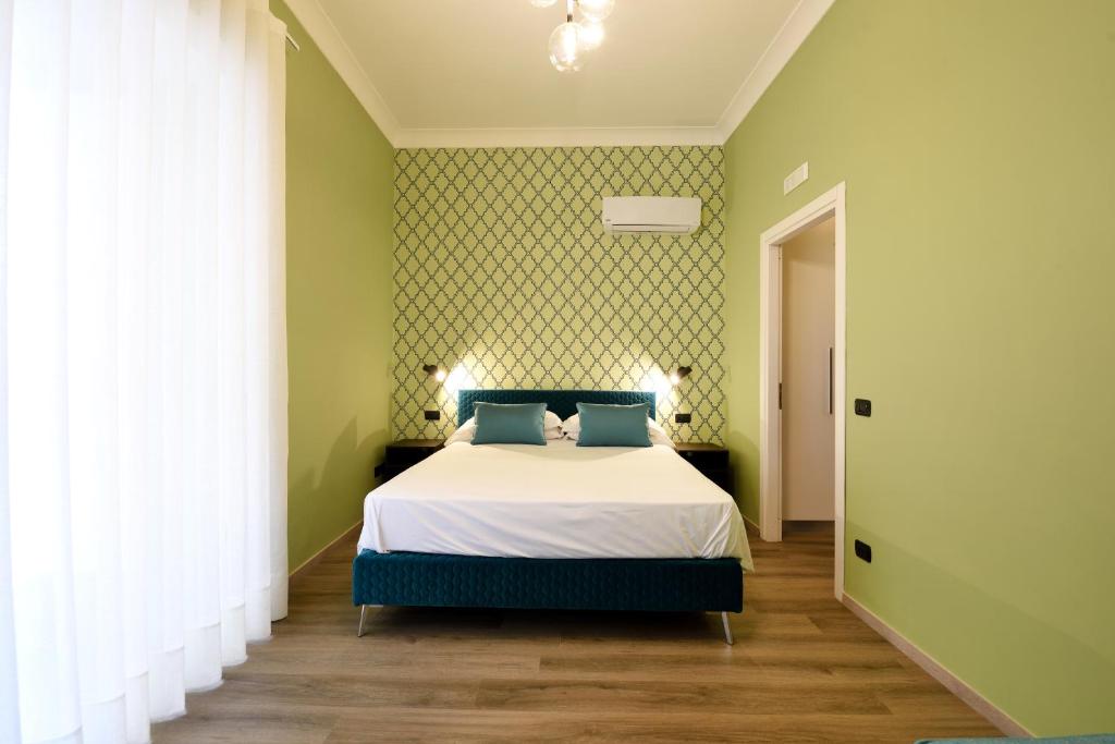 a bedroom with a bed and a green wall at La Casa di Vittoria Sorrento in Sorrento