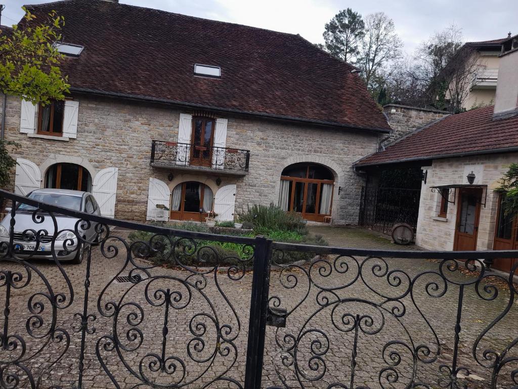 una valla de hierro frente a una casa de piedra en chambre comtoise, 
