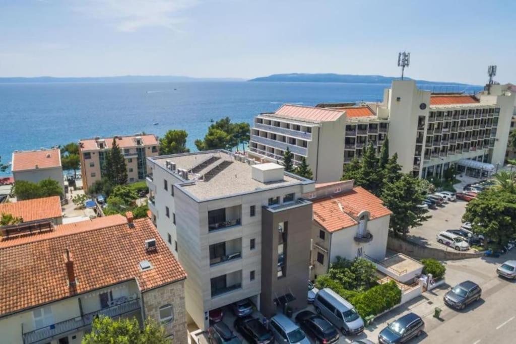 une vue aérienne sur une ville avec des voitures garées dans un parking dans l'établissement Apartmani Vila Jelena 1, à Makarska