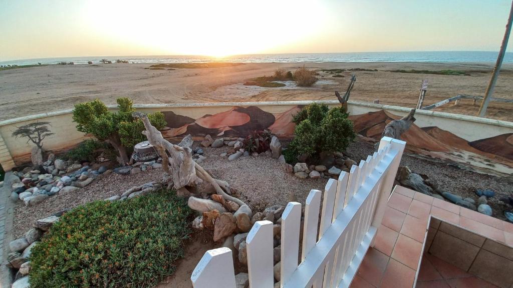 a white fence in front of the beach at Huisie Langs Die See in Swakopmund