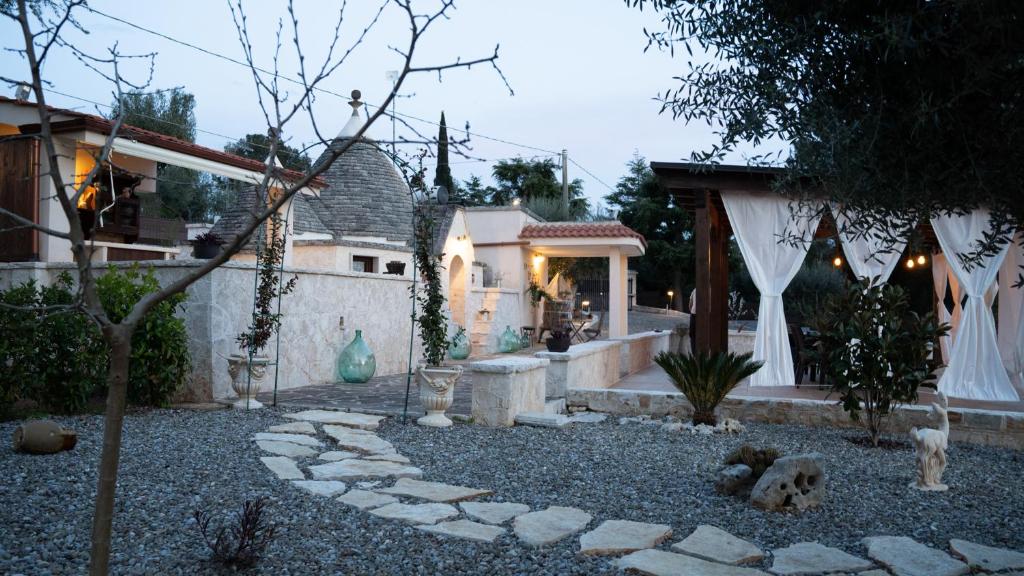a backyard with a stone walkway and a house at Trulli Magnolia in Putignano