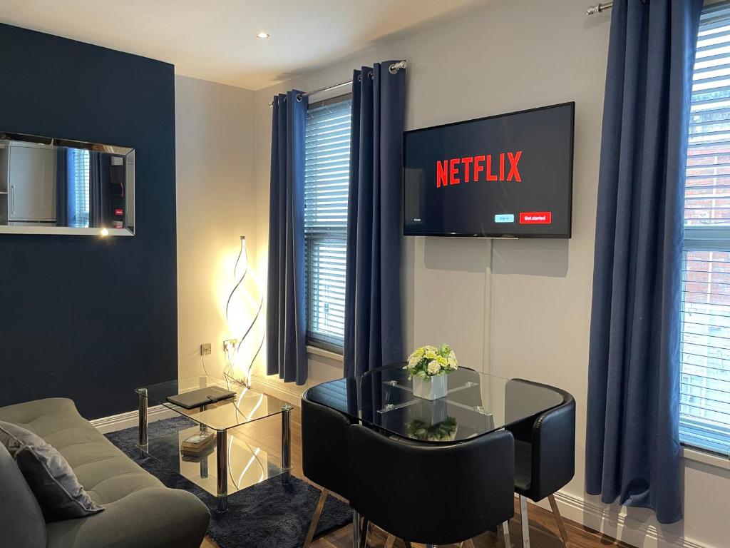 a living room with a couch and a table and a tv at Harvey Apartments in Derry Londonderry