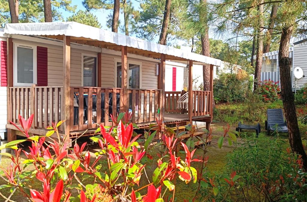 a tiny house with a porch and a deck at Océan Mobilhome Siblu Bonne Anse Village Vacances La Palmyre in Les Mathes