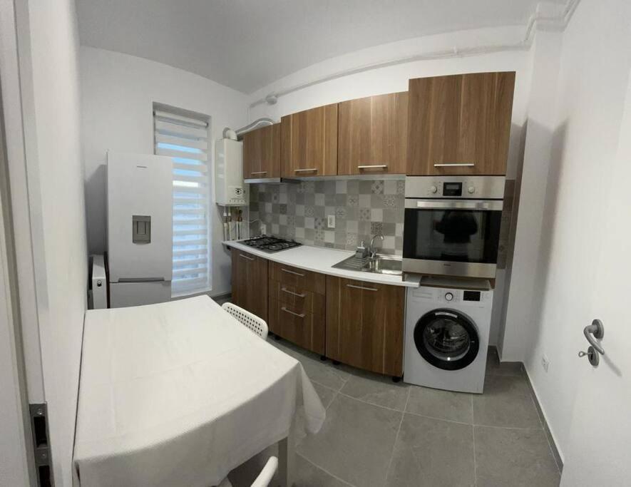 Chiajna的住宿－Apartament cu loc de parcare，厨房配有洗衣机和微波炉。