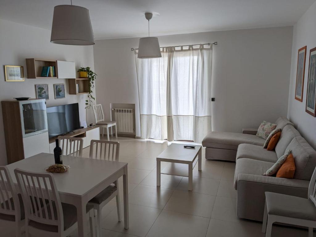 uma sala de estar com um sofá e uma mesa em La Casa dei Due Mari - large apartment with parking em Taranto