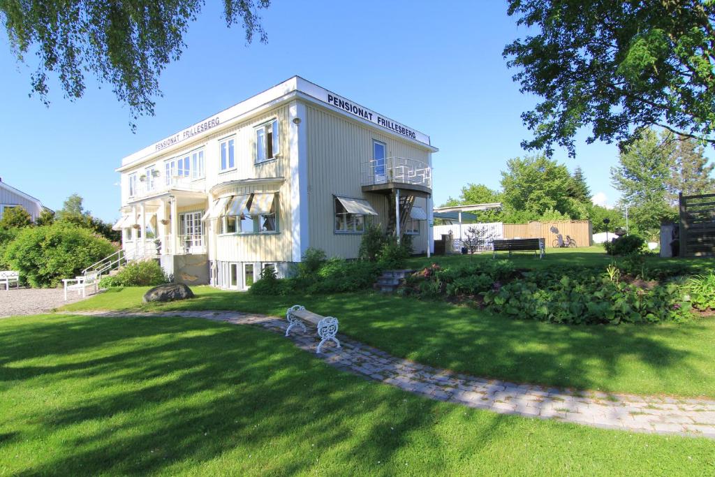 a large white building with a lawn in front of it at Pensionat Frillesberg in Frillesås