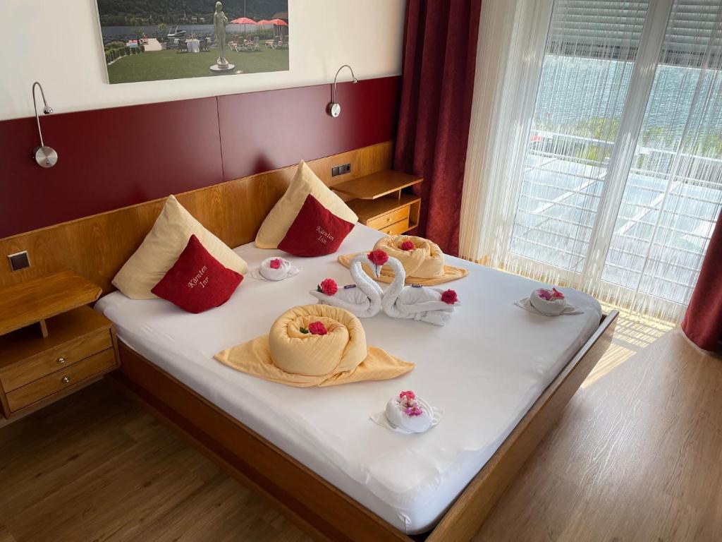 Cama ou camas em um quarto em Hotel Garni &quot;K&auml;rnten Inn&quot; mit direktem Seezugang und E-Ladestation